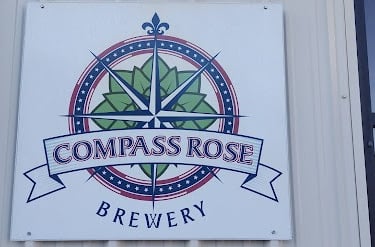 a sign that says compass rose brewing company