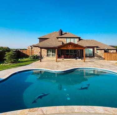 Finished rectangular backyard pool in Forney Texas with a sun shelf, clean coping, and simple concrete decking
