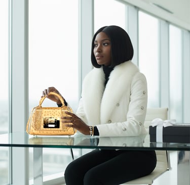 a woman in a white coat and black pants sitting at a table