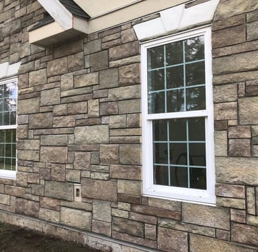 a house with a brick wall and windows