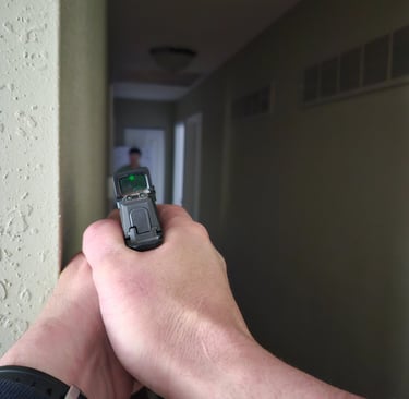 Individual using a personal firearm and self-defense tactics during home defense training.