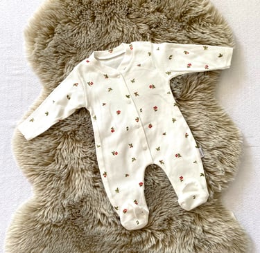 a cute baby's outfit is shown with flowers, colors are bright and beautiful