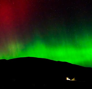 Aurora Borealis Northern Lights bright green and red auroras in the Scottish Highlands