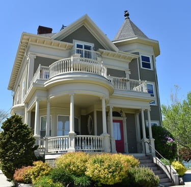 Two-story suburban home with grey siding, white trim and a red door.