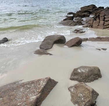 plage de sable avec des rochers et la mer