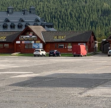 a parking lot with a lot of cars parked in front of a building