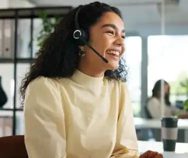 Smiling customer service representative wearing a headset in a modern office workspace
