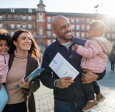 a man and woman holding a child in a plaza