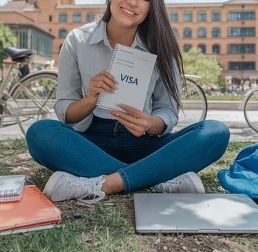 a woman sitting on the grass with a book and a book