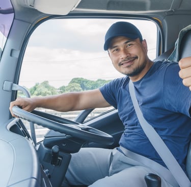 a man in a blue shirt is sitting in a truck