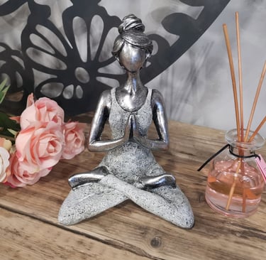 a statue of a woman sitting in a lotus position