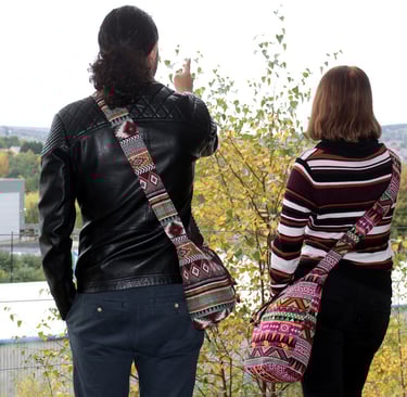 a man and woman standing on a hill overlooking a city