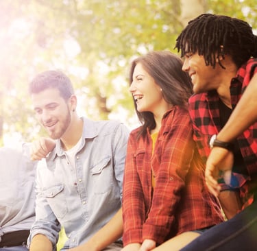 a group of people sitting on a bench in a park