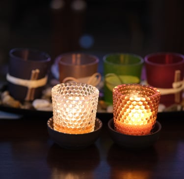 Two lit beeswax votive candles, side by side on a table