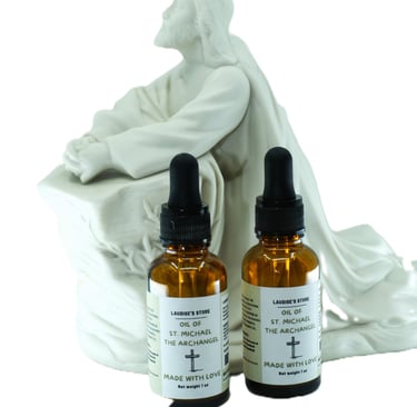 Two bottles of oil of St Michael the Archangel, standing next to a statue of Jesus