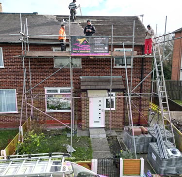 Professional roofers from F&N Roofing performing repairs on a residential brick house using scaffolding.
