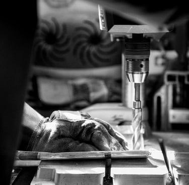 Artisan fabricant de luminaires en train de percer dans son atelier