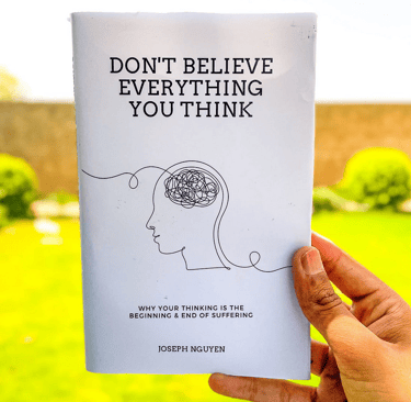 a person holding a book with a drawing of a brain names don't believe everything you think