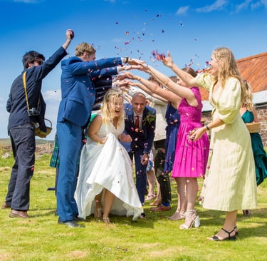 a bride and groom and guests throwing confetti