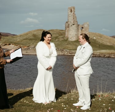 two brides in front of a Highland castle