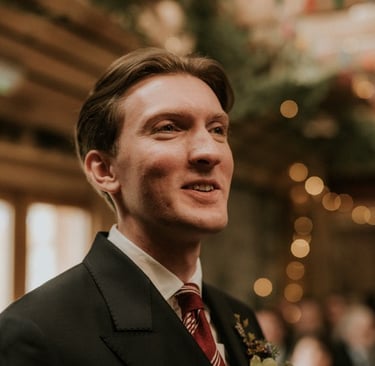 a man in a suit and tie with a flower in his hand
