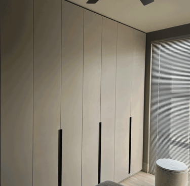 Closet moderno gris con persianas horizontales en recámara iluminada | KARÄNA
