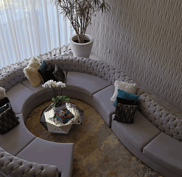 Sala curva desde vista superior, con tapete cálido y mesa central facetada | KARÄNA