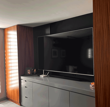 Mueble de TV moderno en acabado gris, con paneles verticales de madera y pared acentuada | KARÄNA