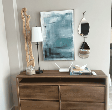 Rincón decorativo con inspiración marina, libros de surf y espejo en forma de gota | KARÄNA