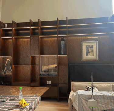 Proceso de montaje de estantería en sala con objetos cubiertos | KARÄNA