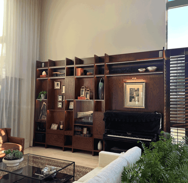 Estantería decorada en sala con piano y luz natural | KARÄNA