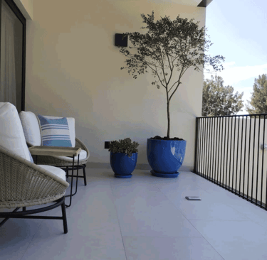 Terraza acogedora con sillones y plantas decorativas en macetas azules | KARÄNA