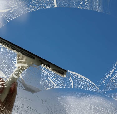 A squeegee smoothly glides over glass surface, leaving behind a streak-free shine