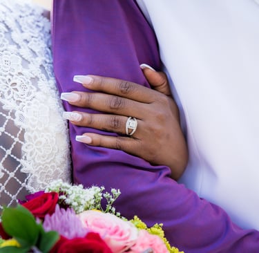 bride holding grooms arm brides wedding band and bouquet 