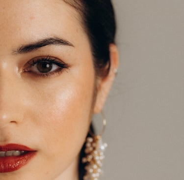 a woman with a red lipstick and earrings