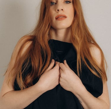 a woman with red hair and a black jacket