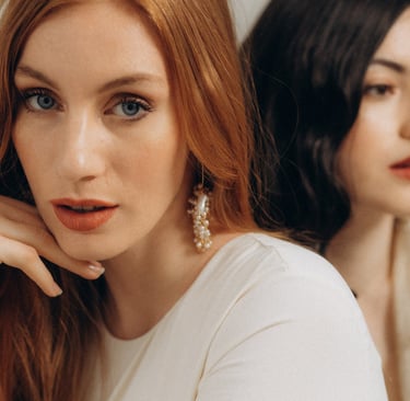 two women with long hair and earrings on their heads