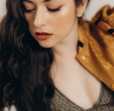 a woman with long hair and a yellow jacket