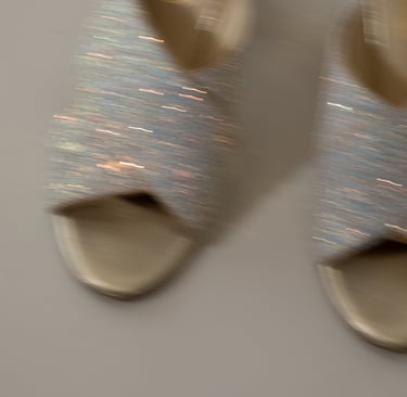a pair of shoes with a silver colored shoelaced on them