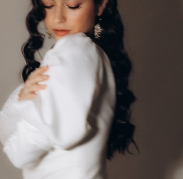 a woman in a white dress with long hair and earrings