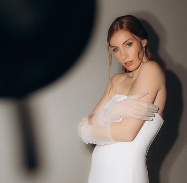 a woman in a white dress with a veil on her shoulder