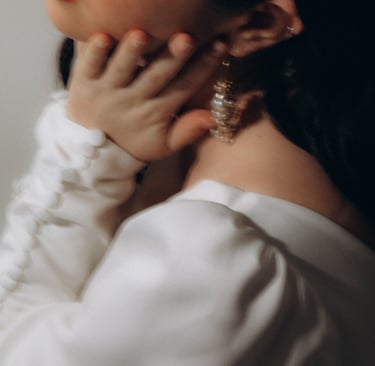 a woman with a white shirt and earrings