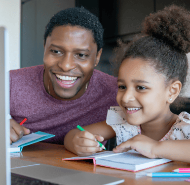 Dad home educating daughter in NZ via laptop and using a notebook.