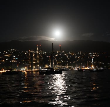 Night view of Tahiti with sailboats and shining moon
