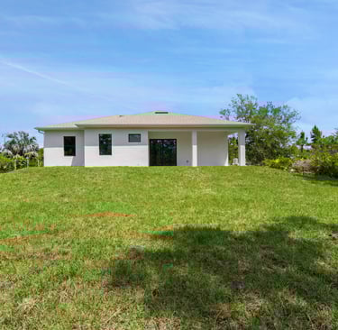 Exterior view of the back of the house, featuring porch and landscape