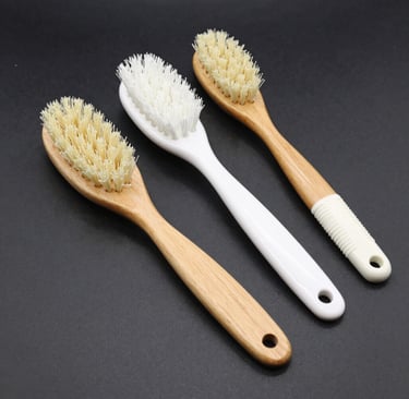 Artisan hands carefully packaging natural wooden brushes in eco-friendly boxes.