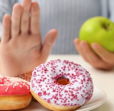 a person holding a doughnut and a cup of coffee green apple