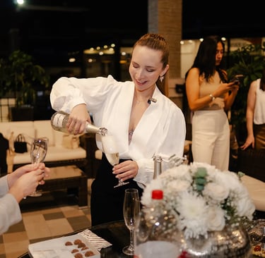 Mujer emprendedora feliz sirviendo champagne en su copa por la inauguración de su negocio