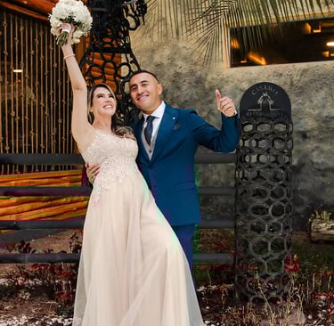 Recién casados celebrando sonriendo a cámara. La novia levanta el ramo y disfrutan de su momento juntos en Quito, Ecuador