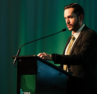 Imagen de hombre elegante hablando por micrófono tomada por fotógrafo en un evento corporativo de lujo en Quito